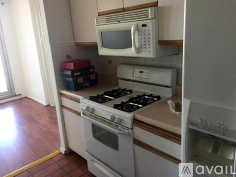 A white microwave oven is mounted above a stove in a kitchen.