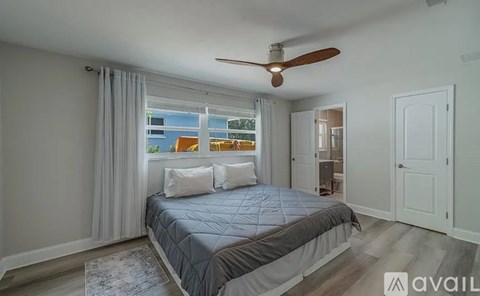 A bedroom with a large bed and a ceiling fan.