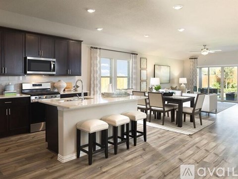 A modern kitchen with dark wood cabinets and a white island.