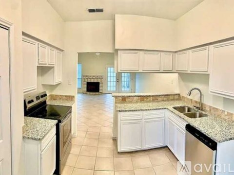 A kitchen with white cabinets and granite countertops.