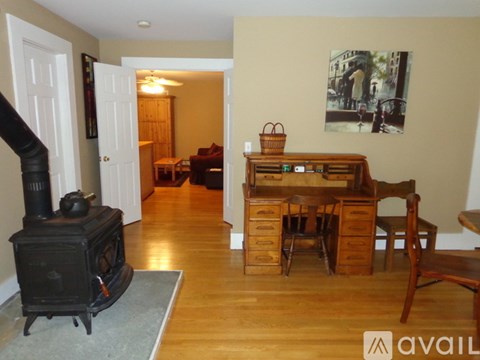A wood burning stove in a living room with a wood table and chairs.