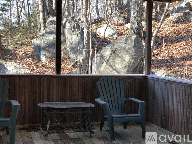 A wooden deck with two chairs and a table.