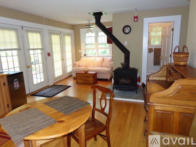 A living room with a fireplace and a dining table.