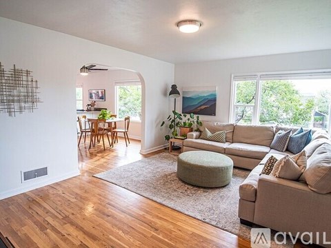 A living room with a couch, a table, and a painting on the wall.