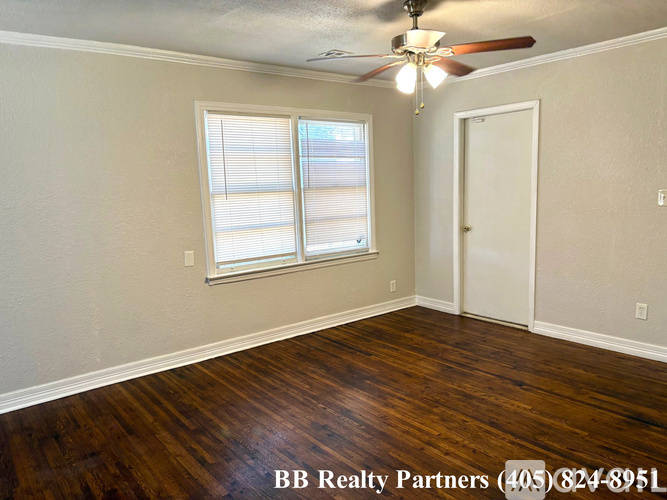 A room with a ceiling fan and a door.