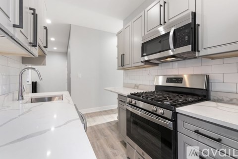 A kitchen with a white countertop and a black stove top oven.
