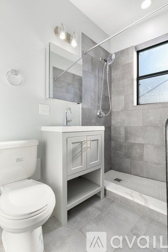 A bathroom with a toilet, sink, and shower.