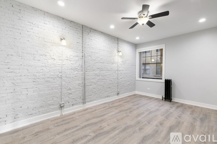 A room with a white brick wall and a ceiling fan.