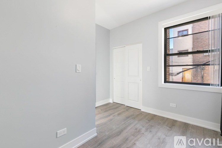 A room with a window showing a building outside.