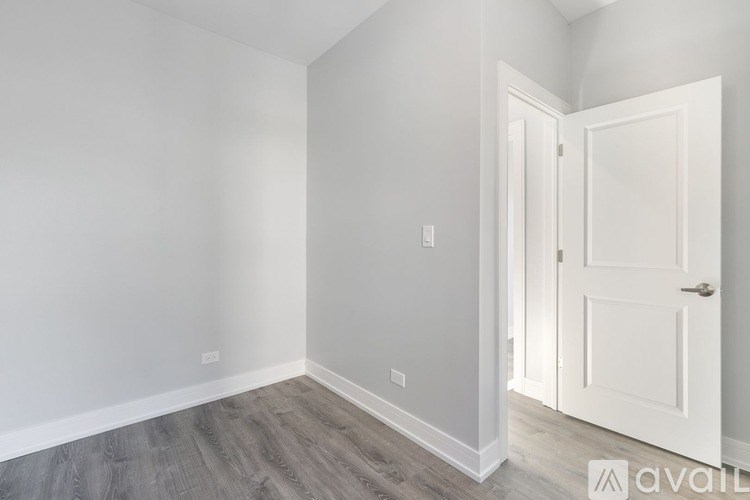 A room with a white door and grey walls.