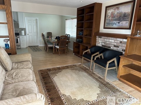 A living room with a grey sofa and a rug.