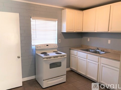 A white stove and oven in a kitchen with white cabinets.