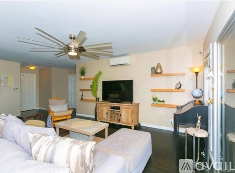 A living room with a white sofa and a wooden cabinet.