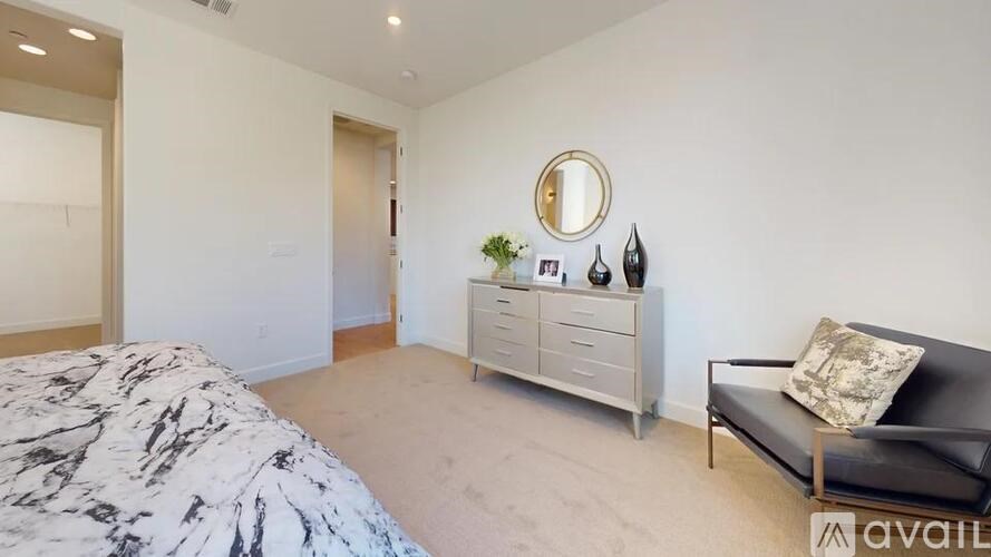 A bedroom with a marble bed, a couch, and a mirror on the wall.