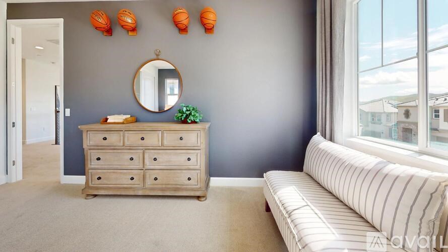 A living room with a wooden dresser and a striped sofa.