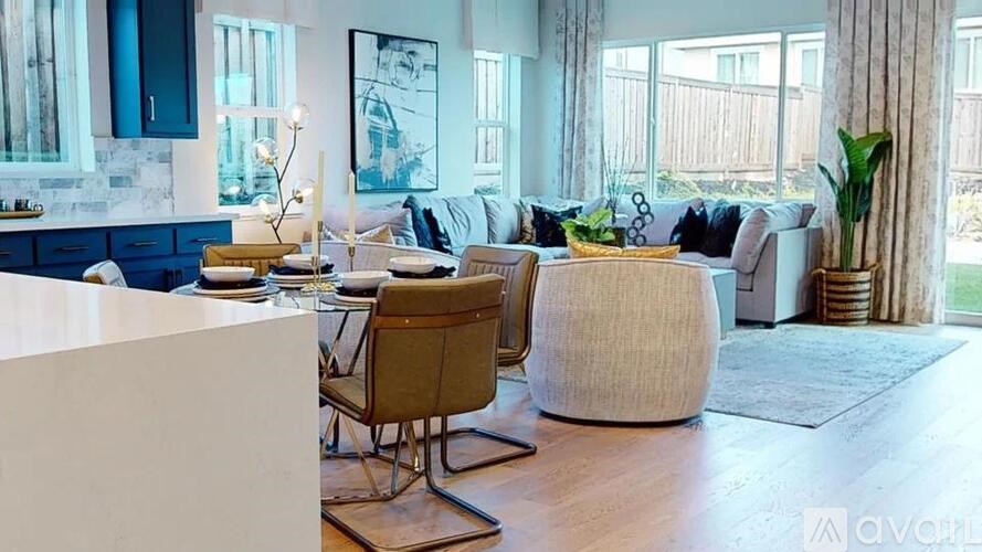 A living room with a white sofa, a wooden coffee table, and a large window.