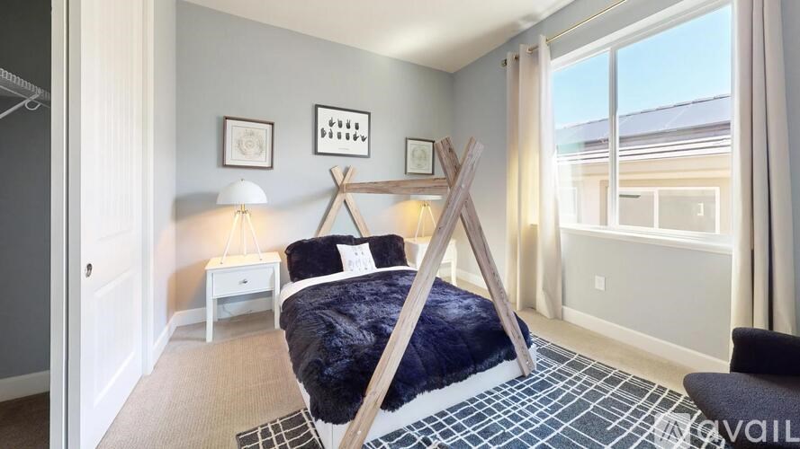 A bedroom with a bed in the center and a chair to the right.