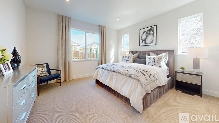 A modern bedroom with a large bed and a grey couch.