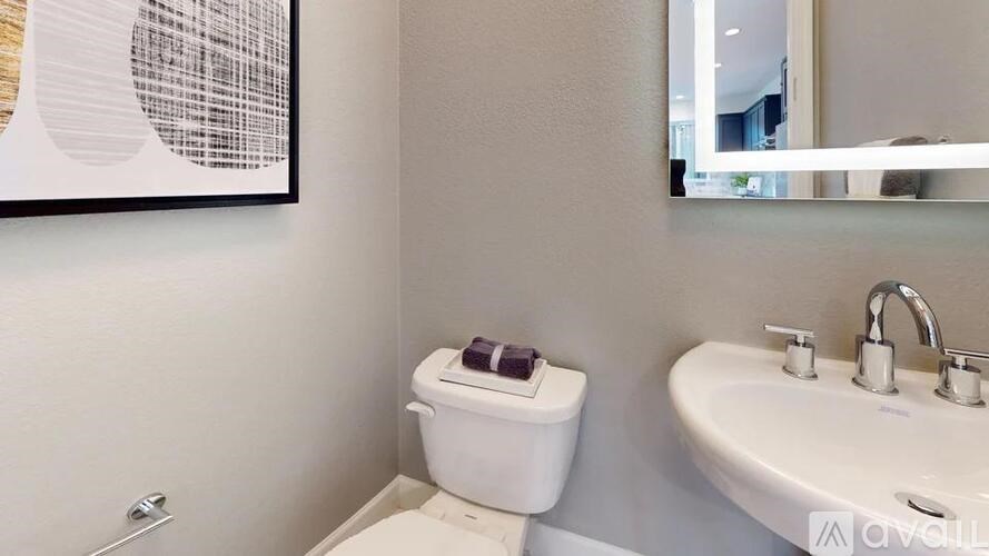 A white toilet sits next to a white sink in a bathroom.