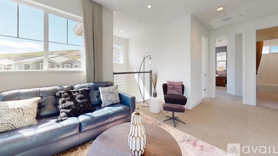 A modern living room with a grey sofa and a brown armchair.