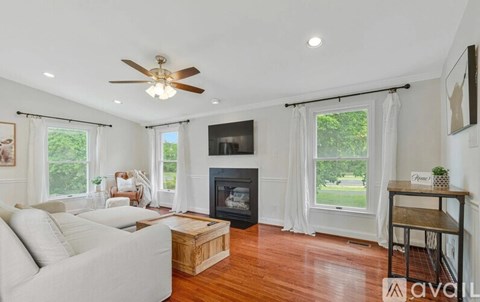 A living room with a white couch and a fireplace.
