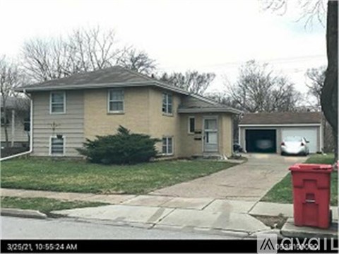 A house with a red trash can in front of it.