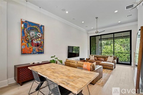 A modern living room with a wooden table and a colorful painting on the wall.