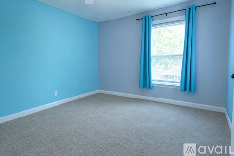 A bedroom with a bed, dresser, and window.