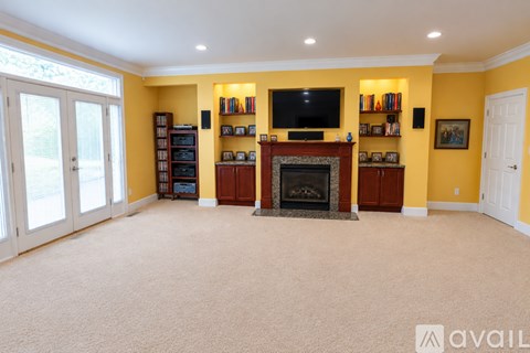 A living room with a brown couch and a fireplace.