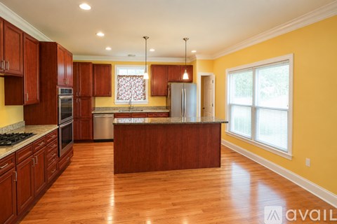 A kitchen with wooden cabinets and a dining table.