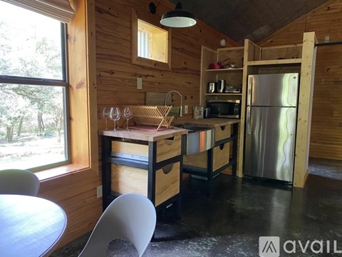 A kitchen area with a table, chairs and a refrigerator.