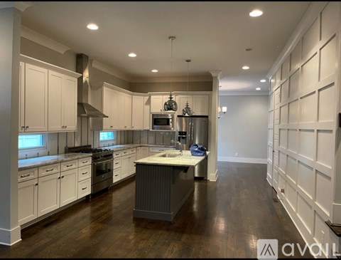 A modern kitchen with white cabinets and a central island.