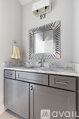 A bathroom with a sink, mirror and cabinet.