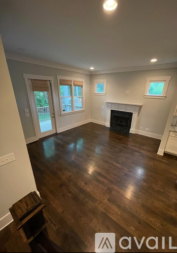 A living room with a fireplace and a wooden floor.