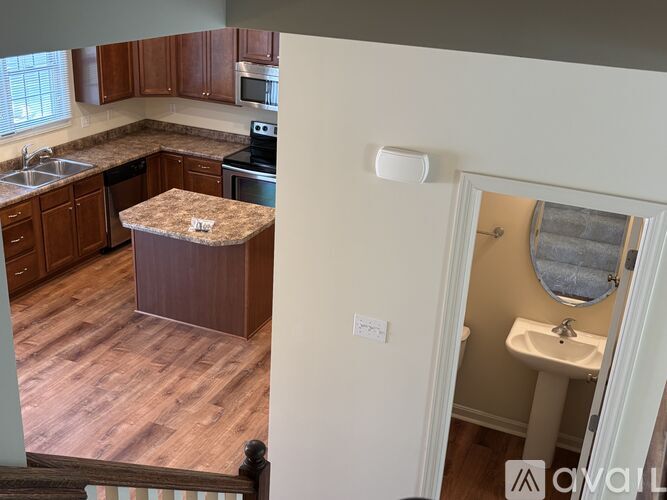 A kitchen with wooden cabinets and a granite island.