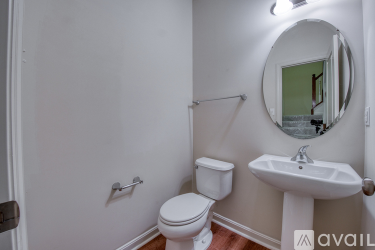 A bathroom with a toilet, sink, and mirror.