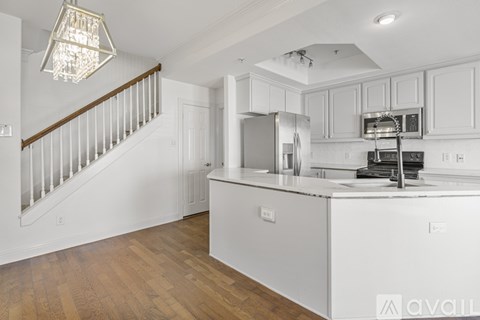 A kitchen with white cabinets and a wooden floor.