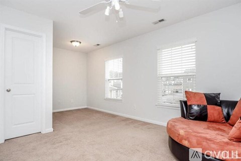 A living room with a red couch and a white door.