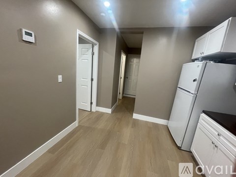 A kitchen area with a refrigerator and cabinets.