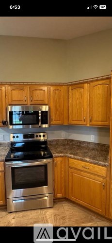 A kitchen with wooden cabinets and a stainless steel oven.
