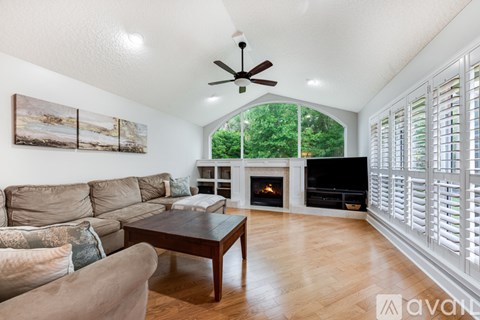 A living room with a fireplace and a painting on the wall.