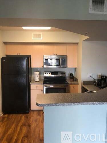 A kitchen with a black fridge, microwave, oven, and stove.