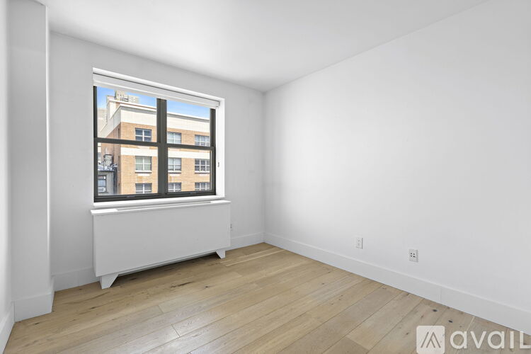A room with a window overlooking a building.