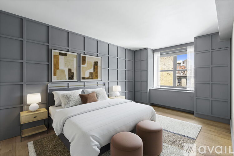 A bedroom with a large bed and a window overlooking a cityscape.