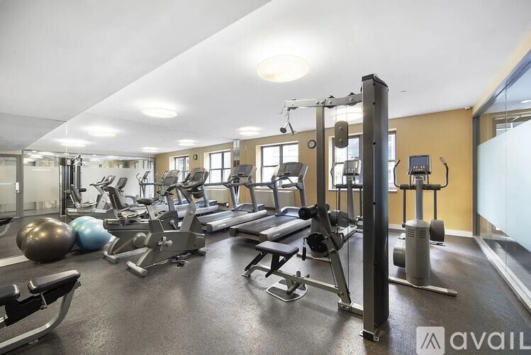 A gym with a variety of equipment including treadmills, weights, and exercise machines.