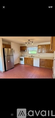 A kitchen with wooden cabinets and a refrigerator.
