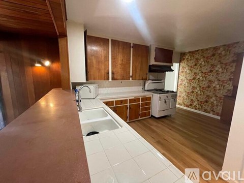 A kitchen with wooden cabinets and a white sink.