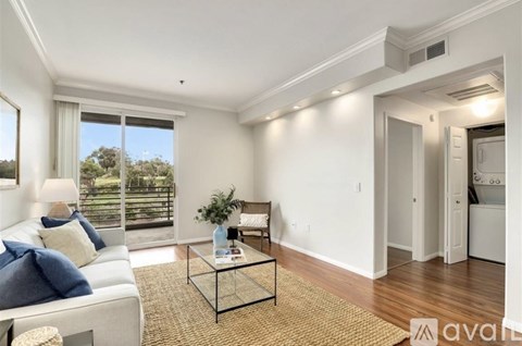 A living room with a white couch and a glass coffee table.