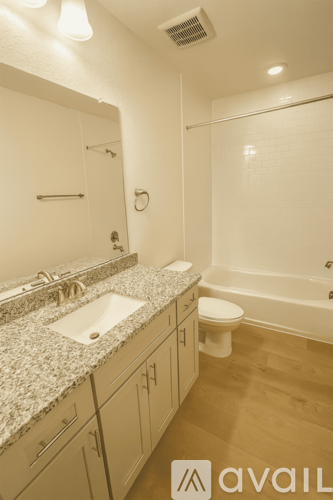 A bathroom with a sink, toilet, and bathtub.