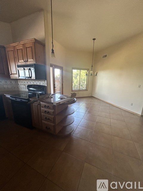 A kitchen with brown cabinets and a black stove top oven.